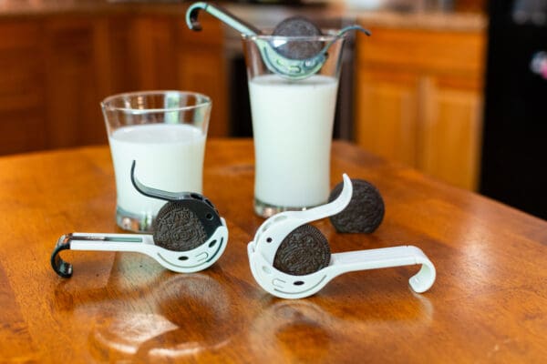 A table with two glasses of milk and cookies.