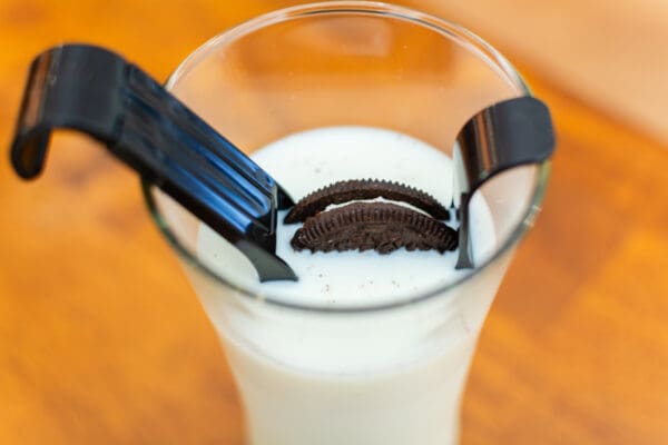 A glass of milk with cookies in it