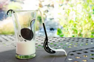 A glass of milk and cookie on the table