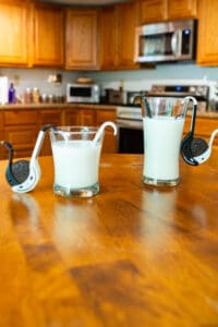 Two glasses of milk on a wooden table.