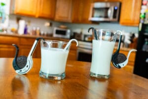 Two glasses of milk on a table in the kitchen.