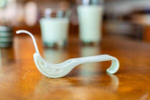 A white pipe sitting on top of a wooden table.