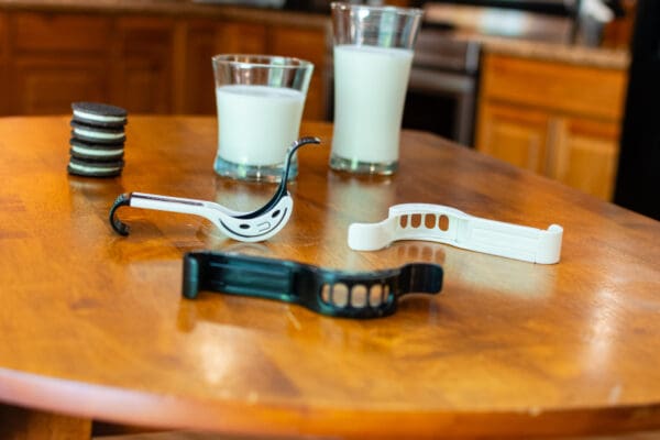 A wooden table with two glasses and some milk.