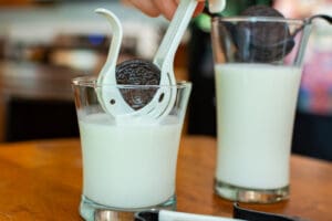 A cup of milk with cookies and milk in it.