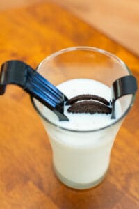 A glass of milk with cookies and a cookie cutter.