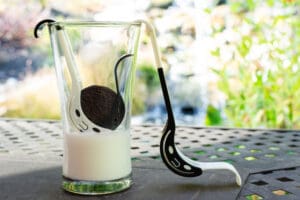 A glass with a spoon and a cup on it